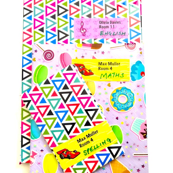 Covered school exercise books labelled with name and subject stickers
